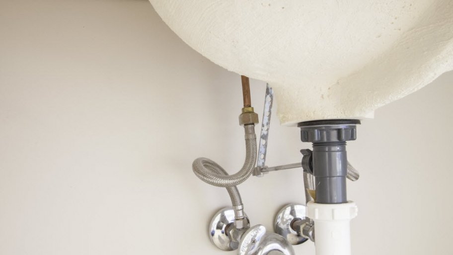 Plumbing pipes under sink pedestal